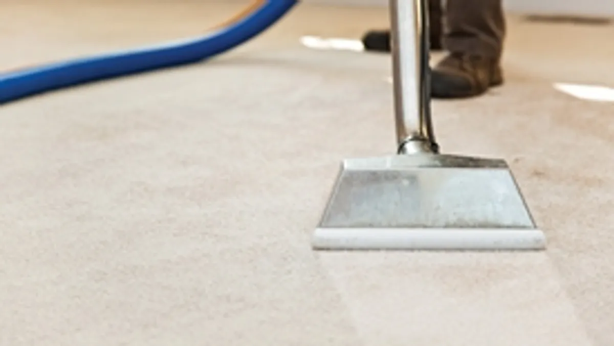 Carpet cleaning wand head gliding over a light carpet during hot-water extraction, Portland, OR.