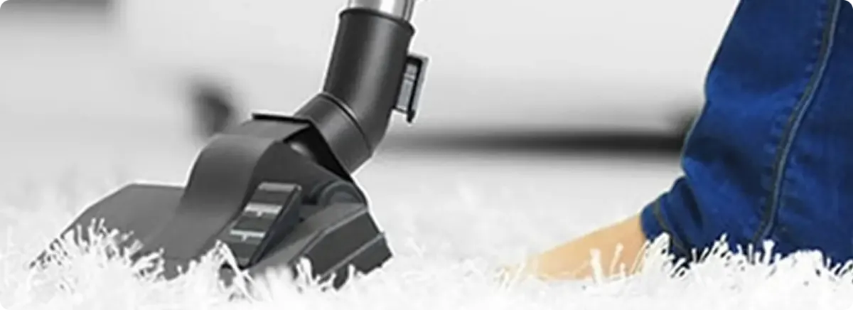Close-up of a professional vacuuming a white carpet in Beaverton.